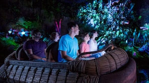 Los Visitantes disfrutando de la bioluminescencia del Na’vi River Journey mientras navegan a bordo de una balsa tejida