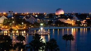 A light house in a lake near palm trees, a resort and Spaceship Earth