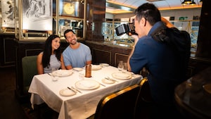 Una pareja sentada posando lado a lado para un fotógrafo en una mesa en 1923, un restaurante de alta cocina