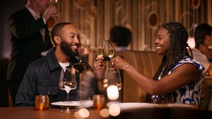 Una pareja brindando con champán mientras disfruta de una comida a bordo de un crucero de Disney