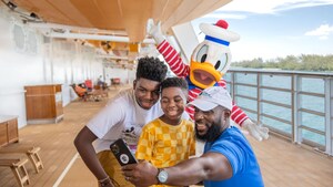 A family of 3 poses for a selfie with Donald Duck aboard a Disney Cruise Line ship