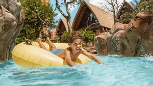 A boy rides a raft through Waikolohe Stream at Aulani, A Disney Resort and Spa
