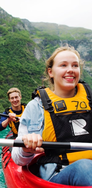 A teenage girl smiles while kayaking