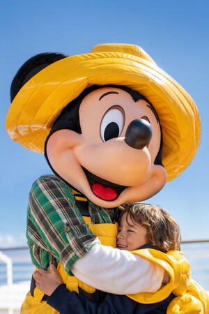 A young girl hugging Mickey Mouse