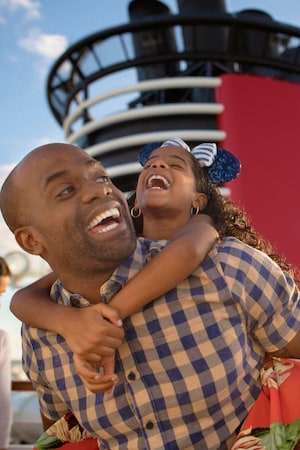 A father and young daughter laughing together on a Disney cruise ship