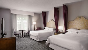 Hotel room with 2 beds, a dresser and a tv