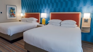 Two queen beds with headboards and Mickey drawing hanging on the wall