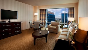 A TV-dresser, oval coffee table, sofa, easy chair, round table with 4 chairs and a large window