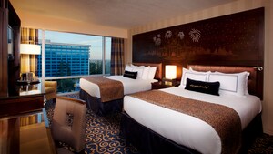 Dos camas Queen Size que comparten una cabecera de Sleeping Beauty Castle, un escritorio, una cómoda con TV y un sillón