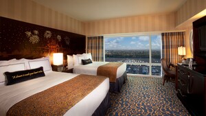 Dos camas Queen Size que comparten una cabecera de Sleeping Beauty Castle, una cómoda con TV y un escritorio