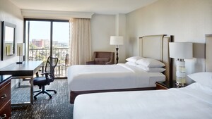 La habitación de huéspedes estándar del Marriott incluye dos camas Queen Size, sillas cómodas, lámparas, un escritorio y un balcón con vista a la ciudad de Anaheim
