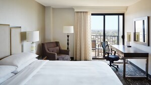 Las habitaciones de huéspedes del hotel Marriott incluyen una cama Queen Size con cabecera de madera, sillas cómodas, lámparas un escritorio y un balcón con vista a la pintoresca ciudad de Anaheim