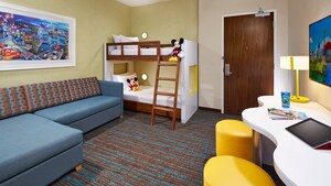 Kids suite living room with sofa, twin bunk beds and large desk with lamp and stools