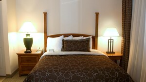 A double bed with a wooden headboard flanked by end tables with lamps