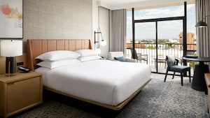 One king bed across from a table and balcony