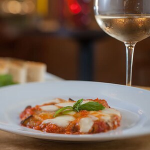 Entrada de abobrinha assada coberta com molho pomodoro, muçarela e parmesão