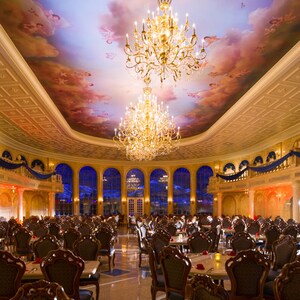 Dois candelabros grandes pendurados no alto da salão de jantar, no Be Our Guest Restaurant, no Magic Kingdom
