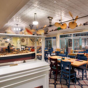 Modelo de navio em um display próximo de mesas e cadeiras no Olivia's Café