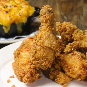 Um prato de frango frito e uma pequena caçarola de macarrão com queijo