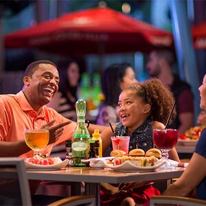 Pai e filha pequena apreciam a refeição e as bebidas no Splitsville Dining Room