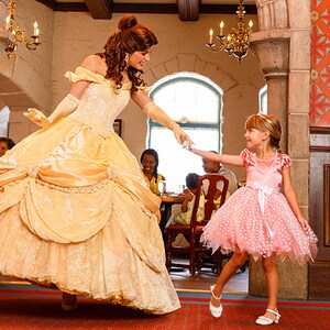 Princesa Belle dança com uma garota vestida de princesa