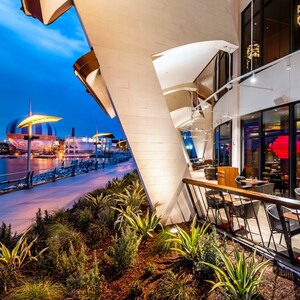 A terrace at Jaleo by José Andrés with tables for 2 people near the lake at Disney Springs