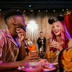 Guests enjoying beverages at a dining table full of dishes at The Edison