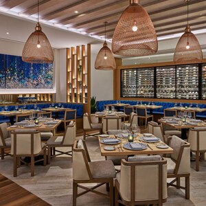 O salão de jantar do restaurante Amare no Walt Disney World Swan Reserve com vinho em destaque 
