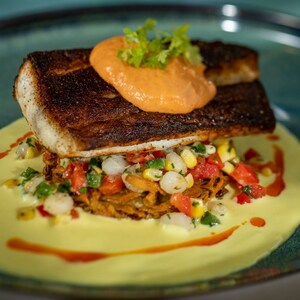 Uma porção de peixe servida com milho e outros legumes