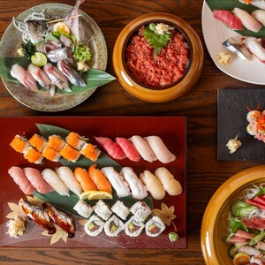 Vários pratos e tigelas com sushi e outras opções
