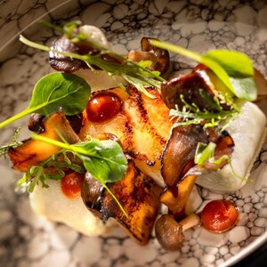 Um Toothfish Bamboo Sambal coberto com folhas verdes e cogumelos
