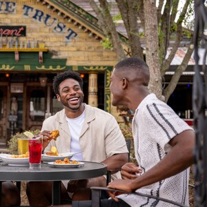 Three men dining outside at a table on the patio near House of Blues Restaurant & Bar