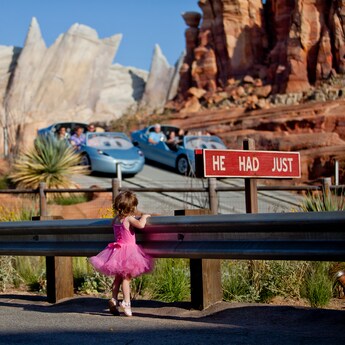 A young girl watching Guests ride Radiator Springs Racers