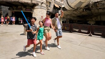 A family walking past the Millennium Falcon at Star Wars: Galaxy's Edge