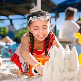A young girl building a sandcastle on the beach