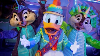 Chip and Dale dressed up as dinosaurs stand next to Donald Duck dressed in a safari outfit