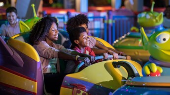 A woman and 2 kids ride Alien Swirling Saucers