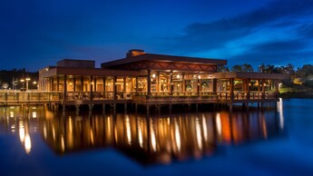 En el exterior de Three Bridges Bar & Grill, en Lago Dorado, sus luces se reflejan en el agua por la noche.