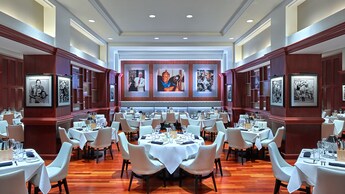 Un comedor con mesas formalmente decoradas y fotos de los Miami Dolphins en las paredes