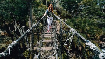 Mulher com um arnês cruza uma ponte de corda em uma expedição guiada da Wild Africa Trek, no Disney’s Animal Kingdom Theme Park