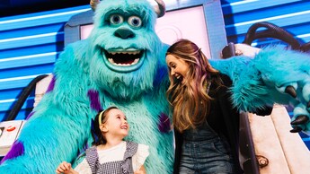 Sulley waits to welcome Guests while standing in front of a door	
