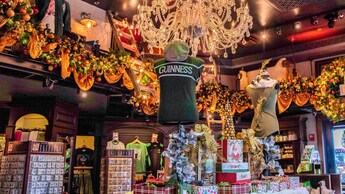 Una tienda con decoración festiva, con un gran candelabro de cristal colgado sobre prendas, alhajas y souvenirs exhibidos 