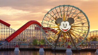 Pixar Pal A Round, una gran rueda de la Fortuna con la cara de Mickey Mouse en el centro, frente a la montaña rusa Incredicoaster en Pixar Pier