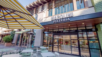 La entrada principal de Napolini Pizzeria cuenta con un comedor en la terraza