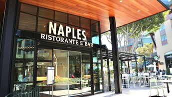 La entrada de estilo moderno de Naples Ristorante e Bar con asientos al aire libre