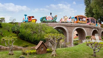 Casey Jr. Circus Train crosses a stone Storybook Land bridge