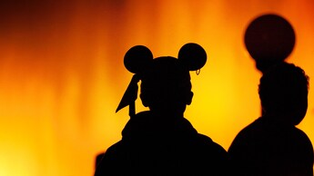 Silhouette of a boy wearing Pirate Mickey Ears against the Pirate chapter of World of Color