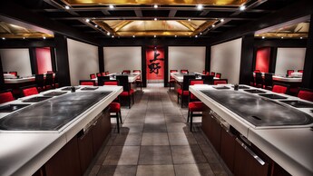 Área de jantar em estilo japonês com mesas e grelhas embutidas