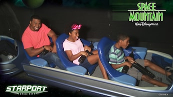 A father, son and daughter in a ride vehicle at Space Mountain