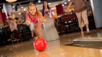 A girl rolling a bowling ball at Splitsville Luxury Lanes at Disney Springs